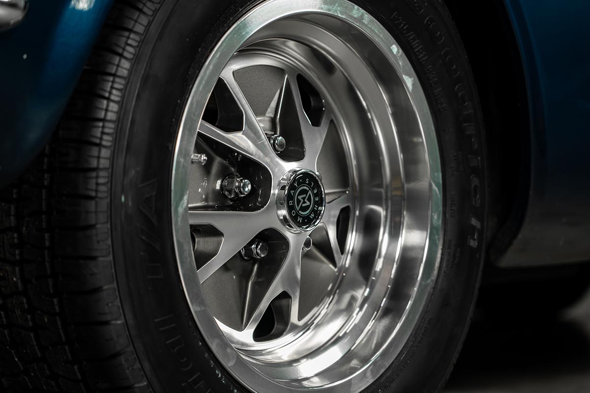 Closeup of Moray Wheels Magnum 500 with gray inserts on a blue classic Mustang